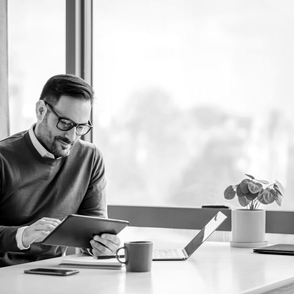 SINGLE-IMAGE_man-with-tablet-at-desk-with-plant_feb24