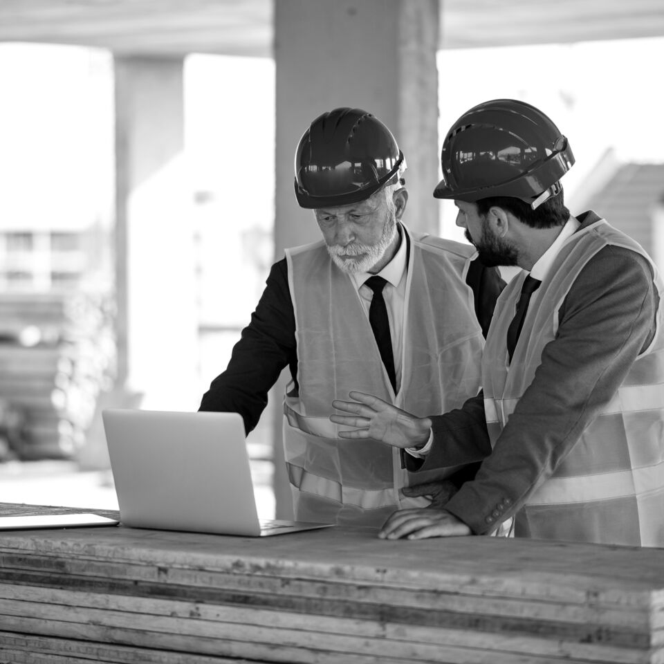 SINGLE-IMAGE_workers-at-construction-site-looking-at-laptop_may25