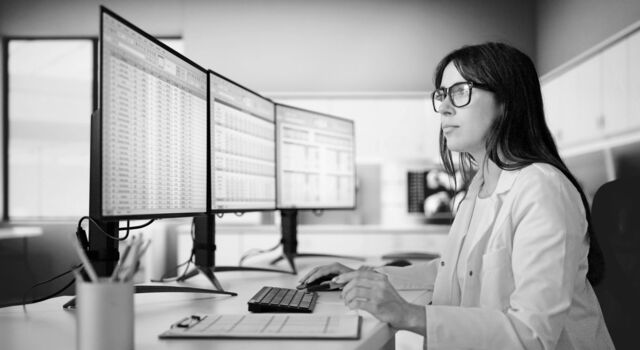 SINGLE-IMAGE_woman-at-computer-triple-monitors_aug25