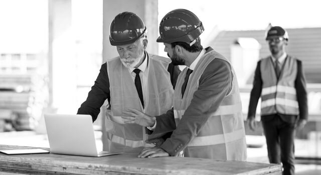 SINGLE-IMAGE_workers-at-construction-site-looking-at-laptop_jan25