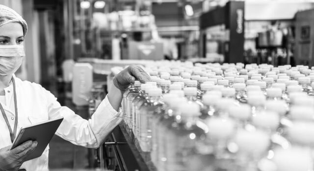 SINGLE-IMAGE_woman-with-tablet-checking-bottles-on-conveyor_nov23