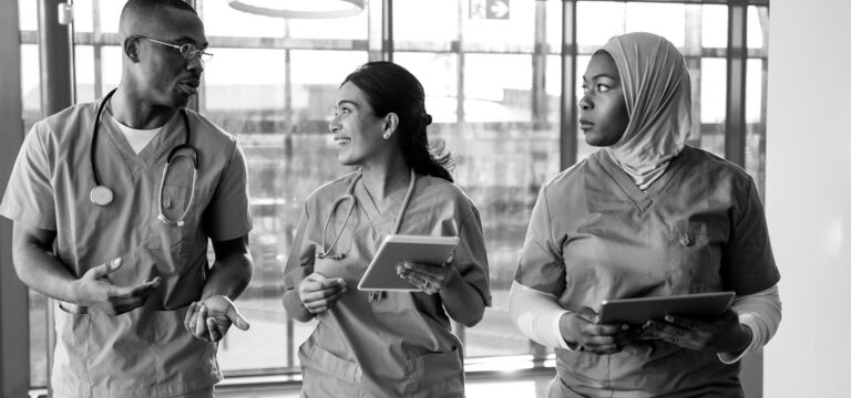 SINGLE-IMAGE_nurses-walking-in-corridor-with-tablet_aug25