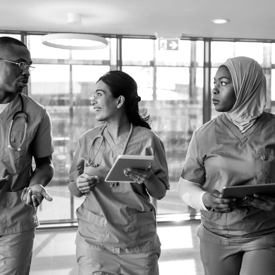 SINGLE-IMAGE_nurses-walking-in-corridor-with-tablet_aug25