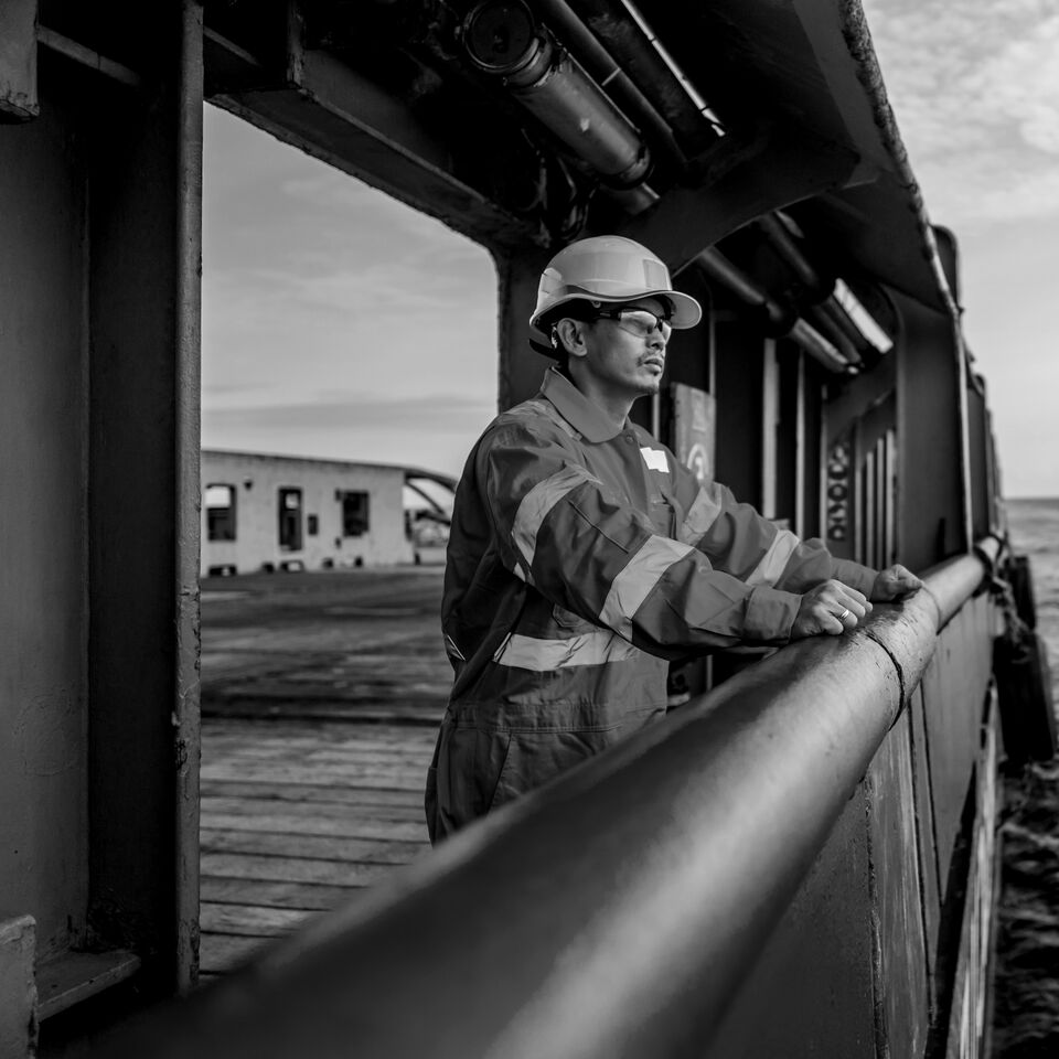 SINGLE-IMAGE_worker-on-boat-looking-to-sea-black-and-white_jul24