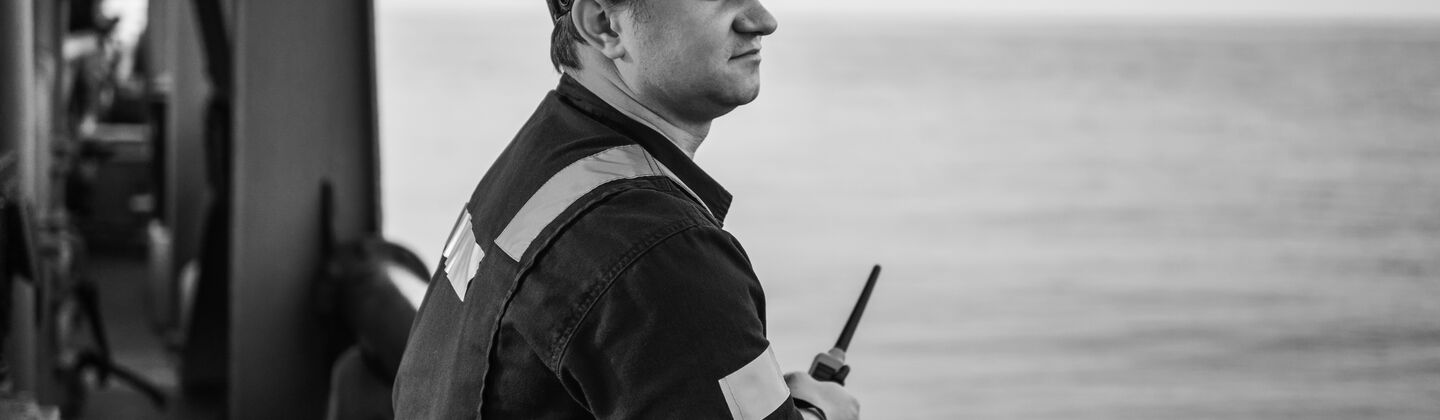 SINGLE-IMAGE_male-engineer-on-deck-holding-walkie-talkie_jul24