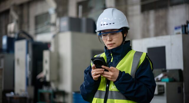 COLOUR-IMAGE_female-worker-EHS-hi-vis-looking-at-mobile-phone_jul26